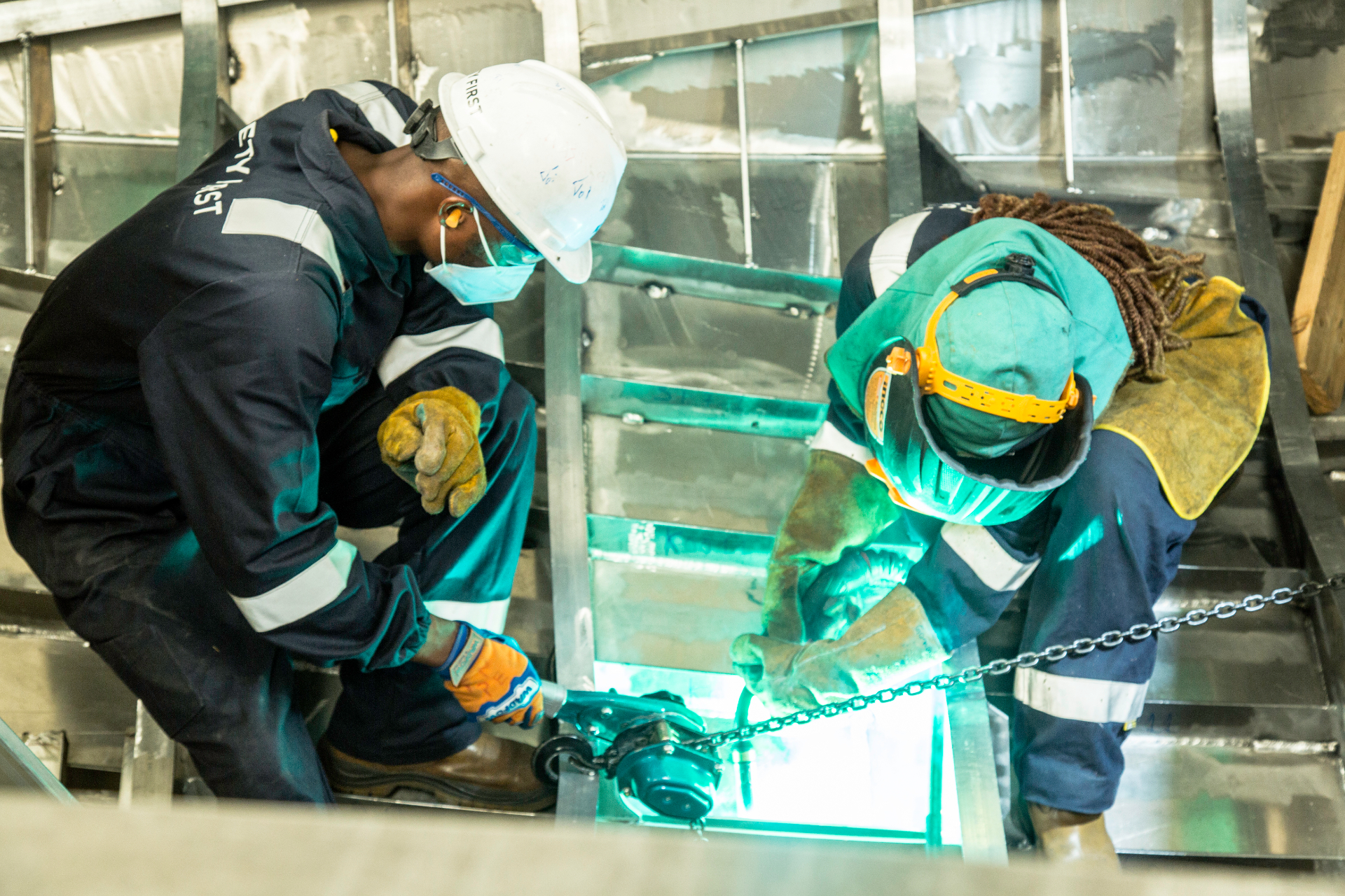 Kianda welders working inside an aluminium vessel hull